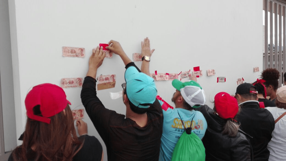 manifestantes pegan billetes manchados en paredes del Banco Central