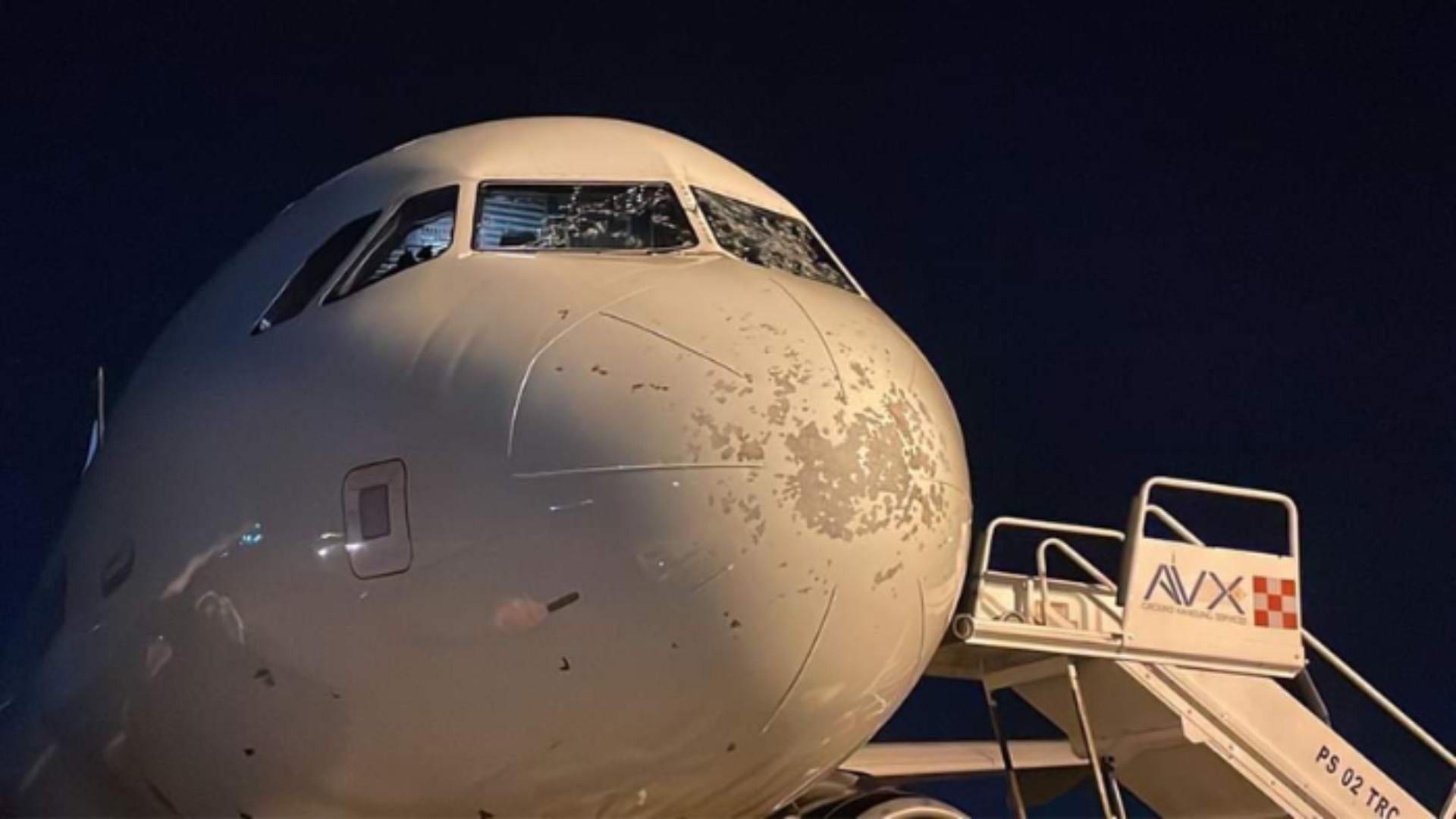 hombre avión parabrisas quebrado por granizo